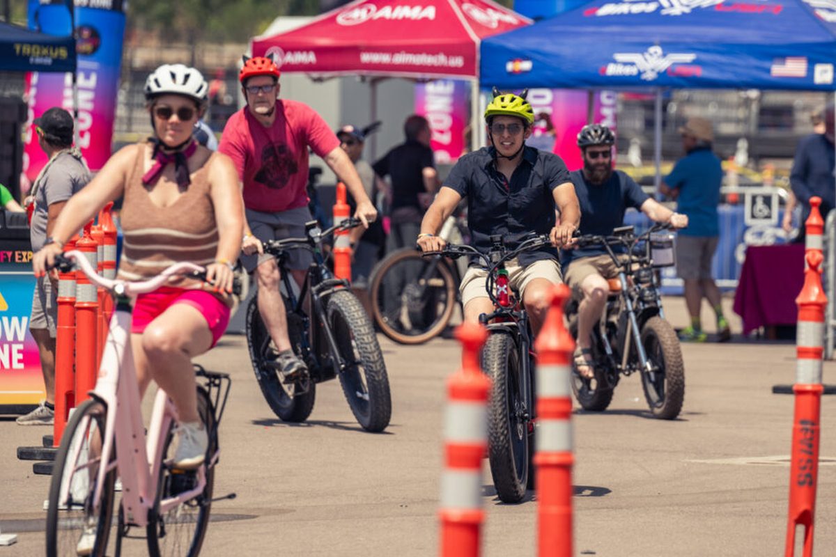 Group of attendees riding electric bikes through the slow zone demo course at Electrify Expo Denver