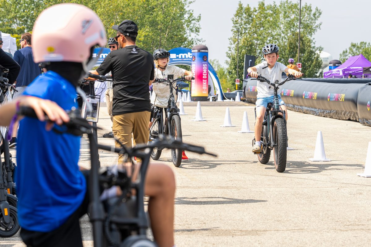 Kids riding electric bikes through the e-bike demo zone at Electrify Expo Chicago