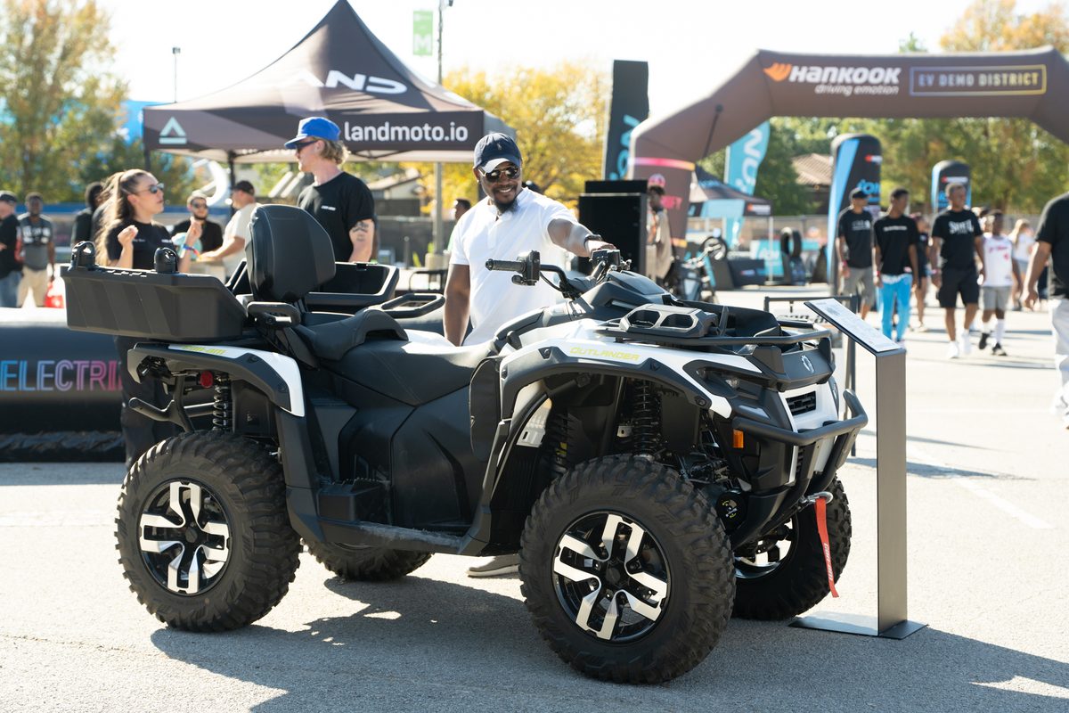 Attendee seated on a Can-Am Outlander electric ATV at the Demo Days Festival EV Demo District in Dallas