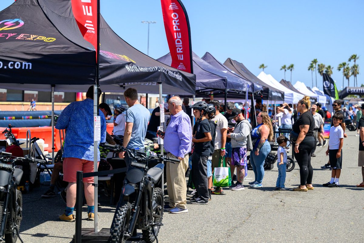 Crowd of attendees browsing e-bike vendor booths at Electrify Expo in Los Angeles