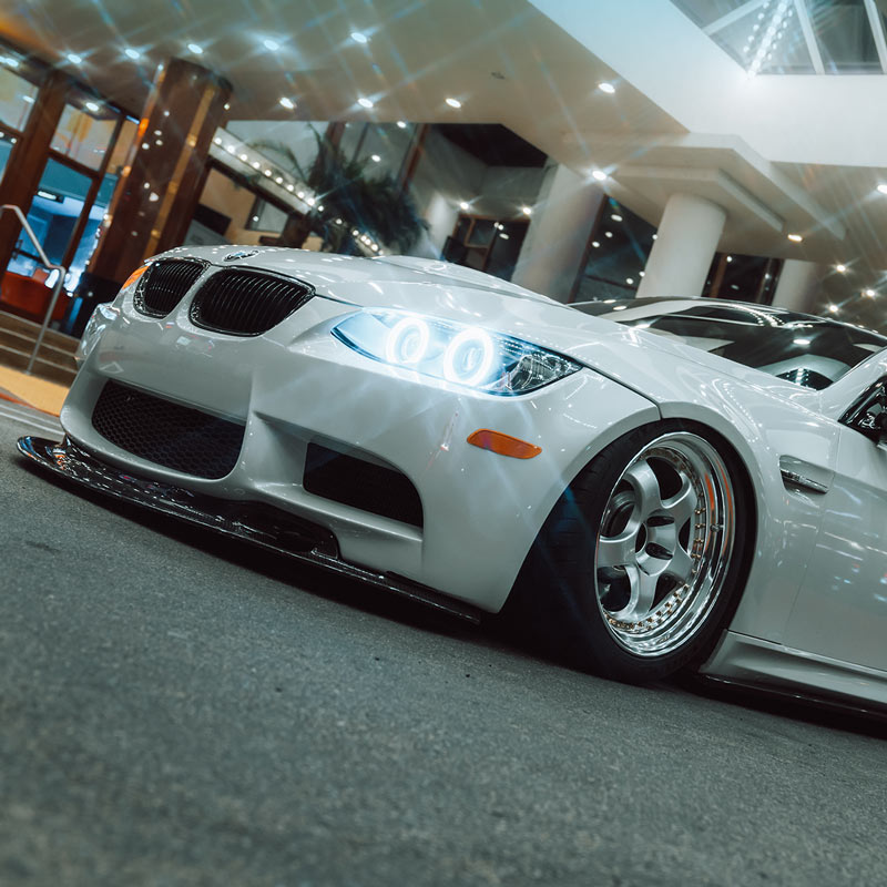 White Euro sports car in a showroom with a modern interior.